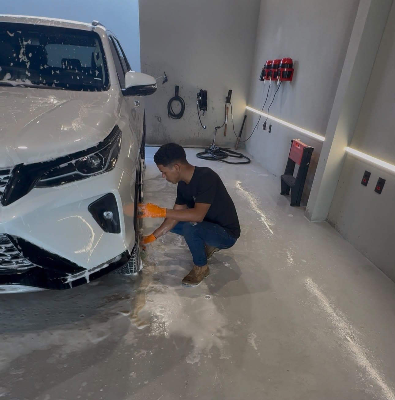 Profissional cuidando da roda de um carro em um lava-jato parceiro